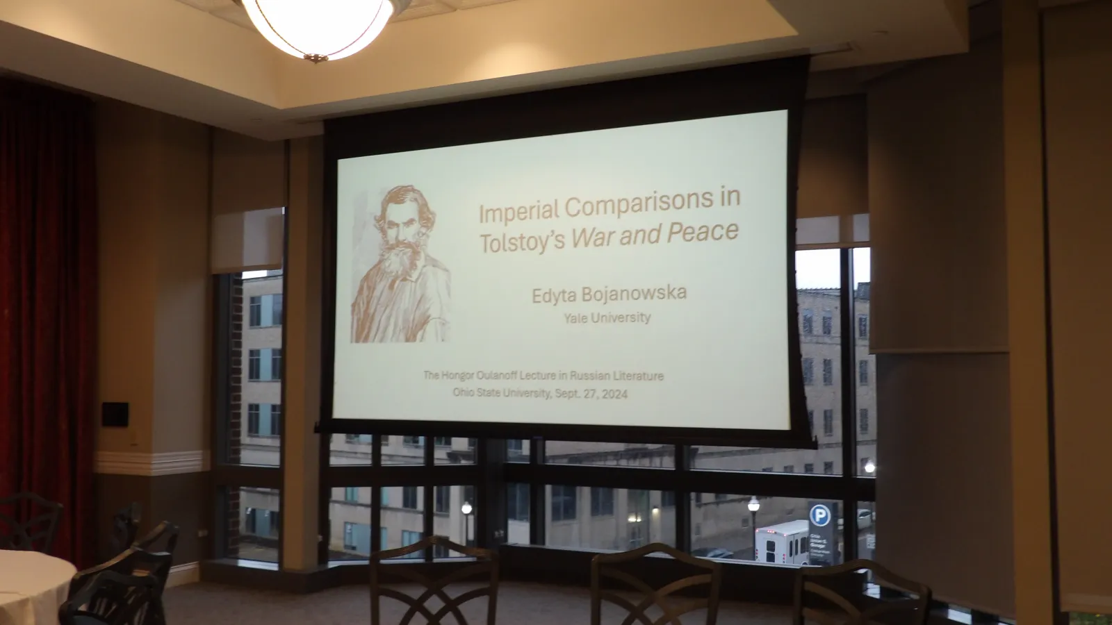 A projector showing a slide with the title of the 2024 Oulanoff lecture.