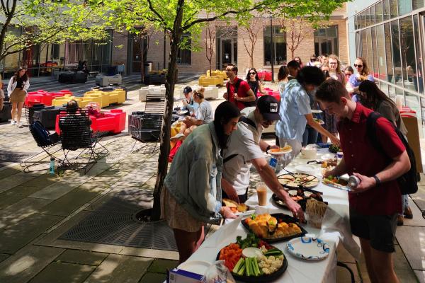 students get food in line at slavic spring tea