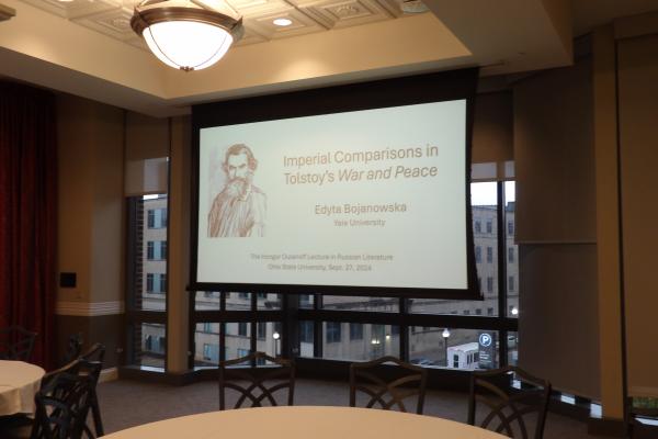 A projector showing a slide with the title of the 2024 Oulanoff lecture.
