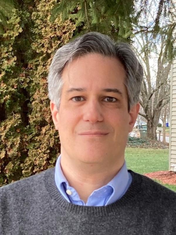 Dr. Burry in front of a tree